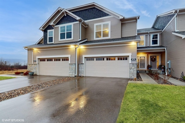 view of front of property with a garage, stone siding, and driveway