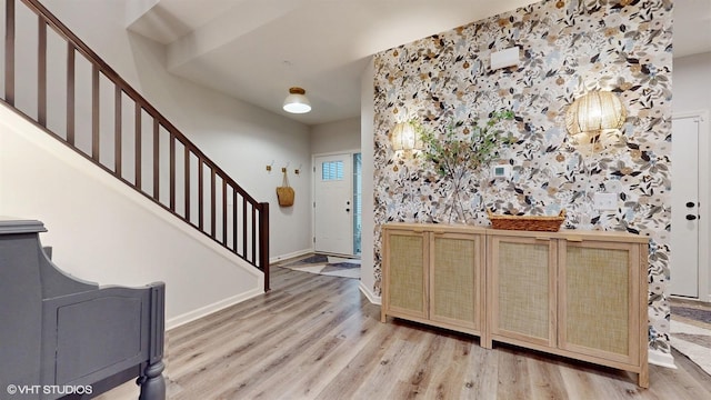 entrance foyer with stairs, wood finished floors, and baseboards