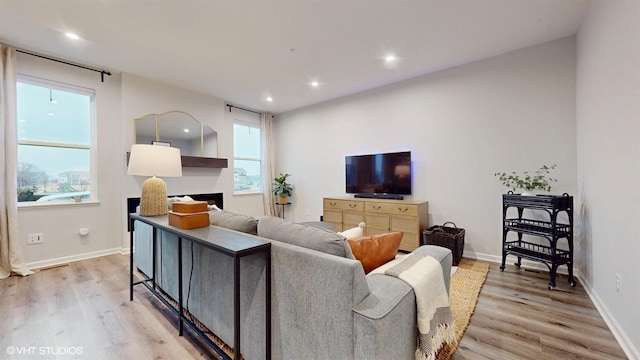 living room with light wood-style floors, baseboards, and recessed lighting