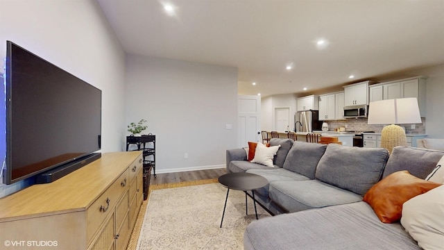 living area with recessed lighting, baseboards, and light wood finished floors