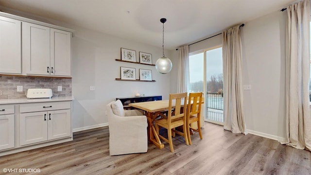 dining room with baseboards and light wood finished floors