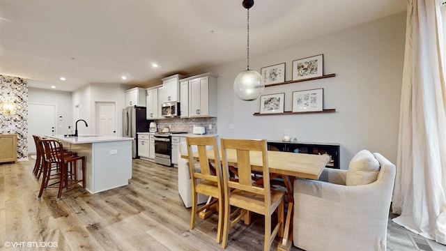 dining space with light wood-style floors and recessed lighting