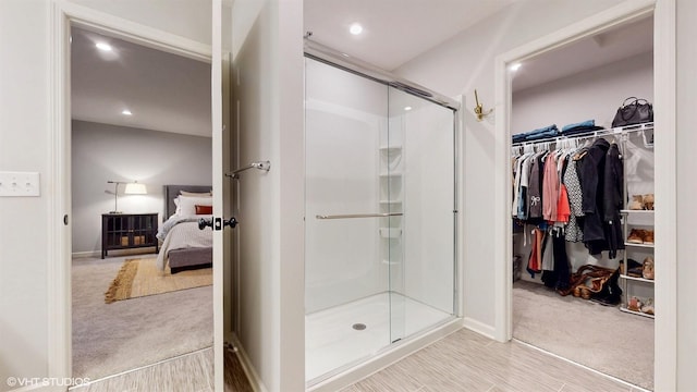 bathroom featuring a stall shower, a spacious closet, and recessed lighting