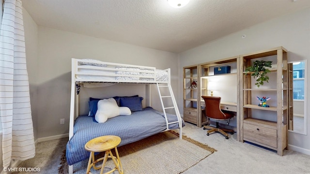 carpeted bedroom featuring a textured ceiling and baseboards