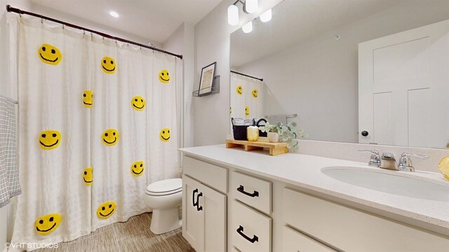 bathroom featuring a shower with shower curtain, vanity, and toilet