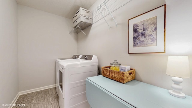 washroom featuring laundry area, baseboards, and washing machine and clothes dryer