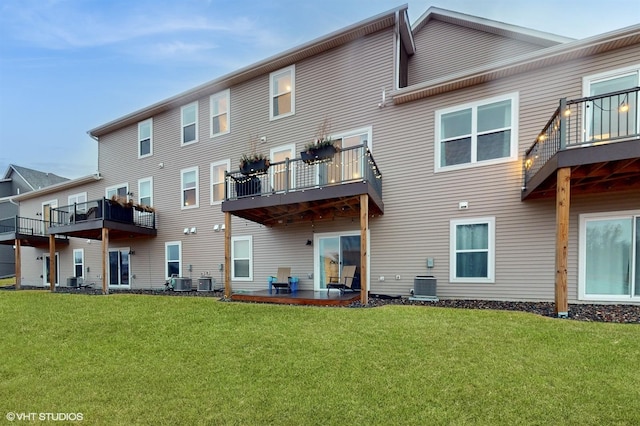 rear view of house featuring a patio, central AC unit, and a lawn