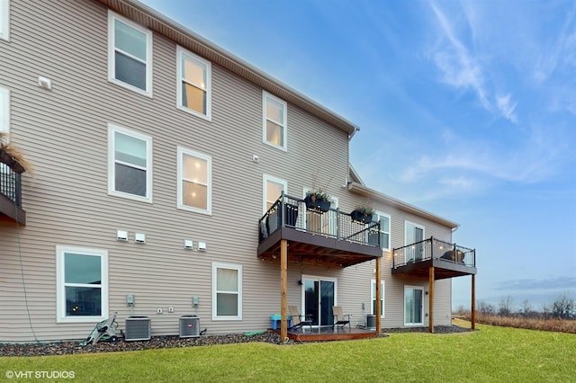 rear view of property featuring central AC, a lawn, a balcony, and a patio