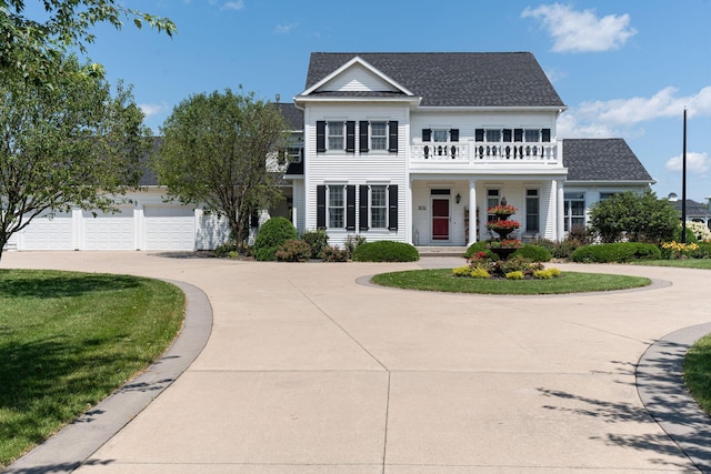 view of front of house with a garage, concrete driveway, a balcony, roof with shingles, and a front lawn