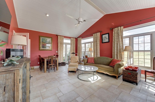 living room with lofted ceiling, stone finish flooring, baseboards, and ceiling fan