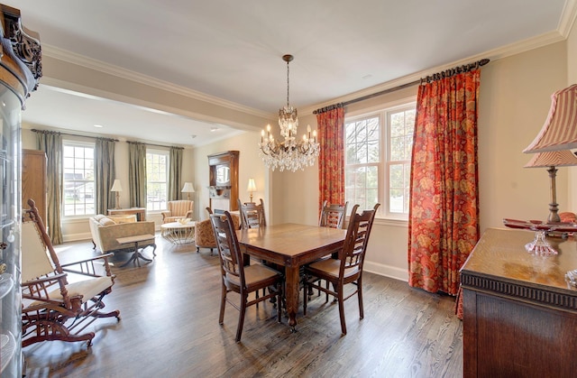 dining room featuring baseboards, ornamental molding, a chandelier, and wood finished floors