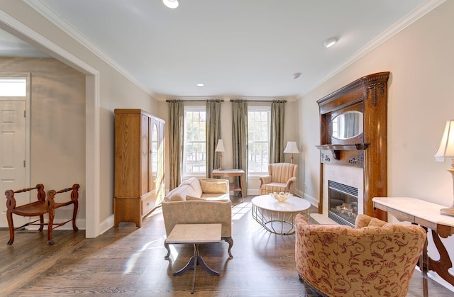 living room featuring crown molding, baseboards, and wood finished floors