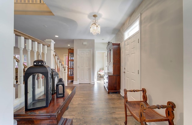 entryway featuring baseboards, wood finished floors, an inviting chandelier, stairs, and recessed lighting