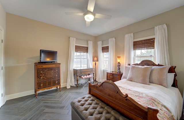 bedroom featuring multiple windows, a ceiling fan, and baseboards