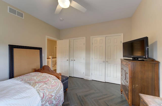 bedroom featuring a ceiling fan, visible vents, and multiple closets