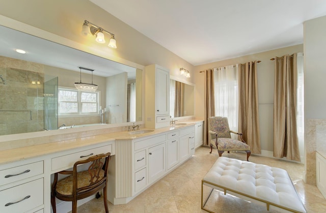 bathroom featuring double vanity, a stall shower, a sink, and tile patterned floors