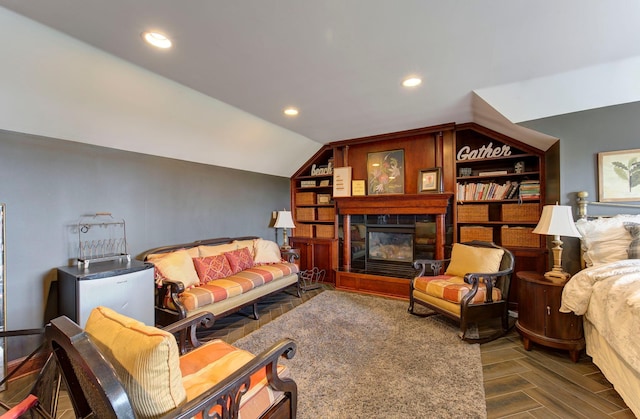 living area featuring a glass covered fireplace, wood finished floors, vaulted ceiling, and recessed lighting