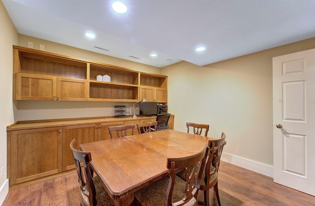 dining space featuring dark wood-style floors, built in desk, baseboards, and recessed lighting