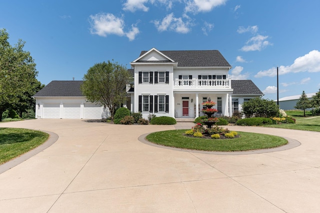 view of front of home with a garage, curved driveway, and a balcony