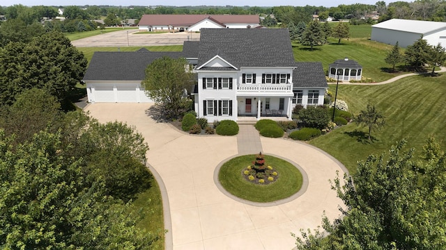 view of front of home with roof with shingles, curved driveway, a porch, a balcony, and a garage