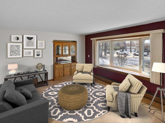 living area with a baseboard heating unit and a textured ceiling