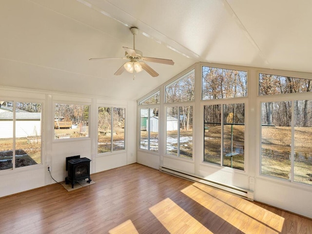 unfurnished sunroom with a ceiling fan, a baseboard radiator, a wood stove, and lofted ceiling with beams