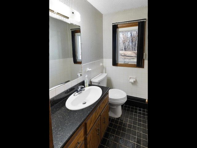 bathroom featuring wallpapered walls, wainscoting, toilet, tile patterned floors, and a textured ceiling