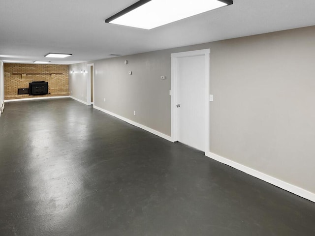 finished basement featuring a wood stove and baseboards