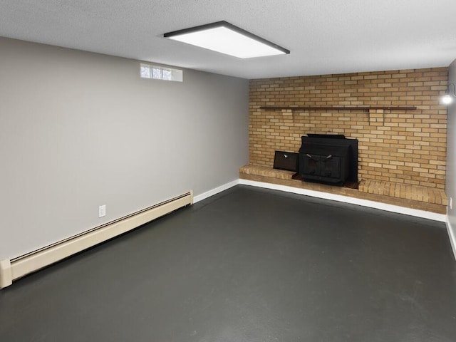 unfurnished living room featuring baseboards, a baseboard radiator, a wood stove, a textured ceiling, and concrete flooring