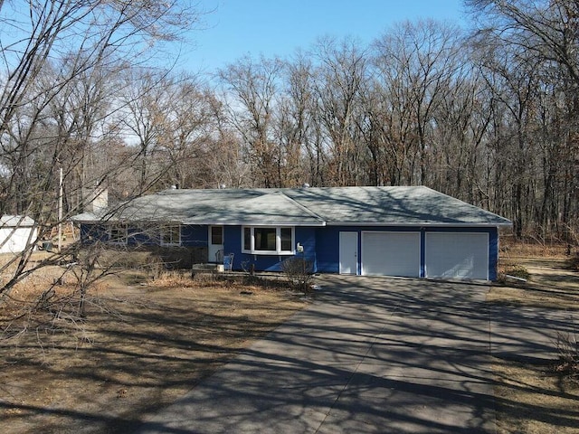 single story home featuring a garage and driveway