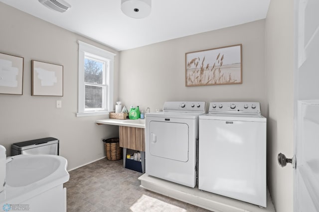 laundry area featuring laundry area, visible vents, baseboards, light floors, and washing machine and dryer