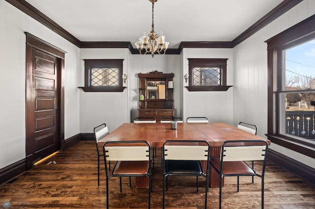 dining space with baseboards, ornamental molding, dark wood-style flooring, and a notable chandelier