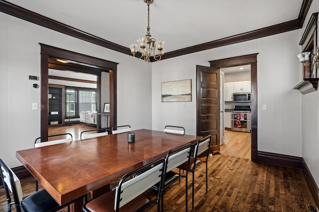 dining space featuring wood-type flooring, ornamental molding, a chandelier, and baseboards