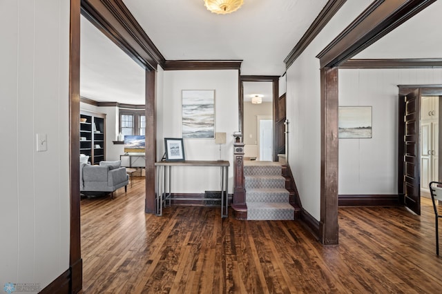 interior space with baseboards, ornamental molding, and wood finished floors