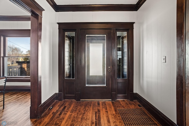 entrance foyer featuring dark wood-style floors, baseboards, and crown molding