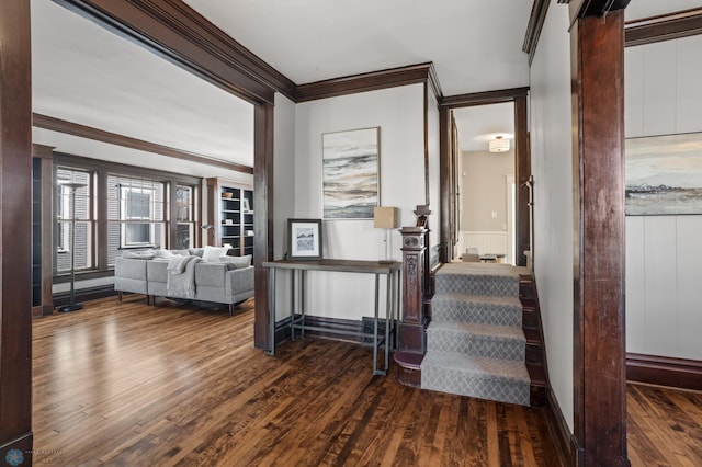 stairs with wainscoting, wood-type flooring, and crown molding