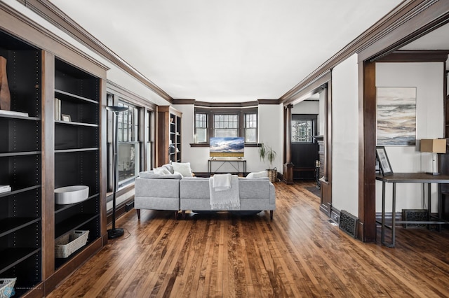 bedroom with dark wood-style floors, baseboards, and crown molding