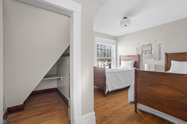 bedroom featuring baseboards and wood finished floors