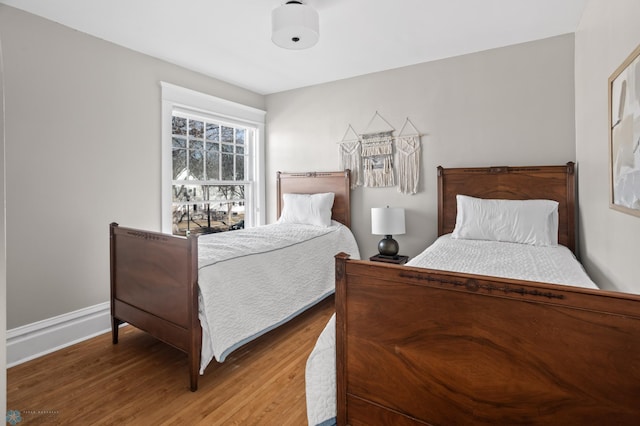 bedroom featuring baseboards and wood finished floors