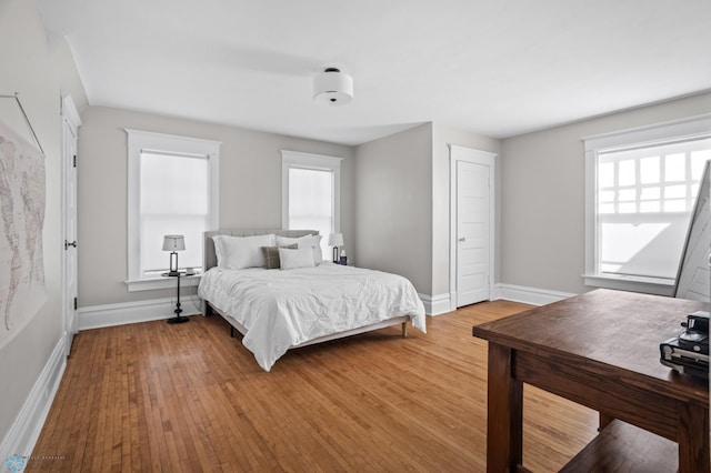 bedroom with hardwood / wood-style floors and baseboards