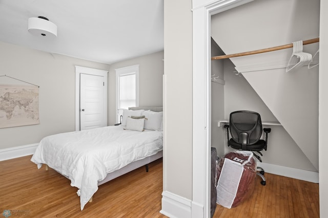 bedroom featuring wood-type flooring and baseboards