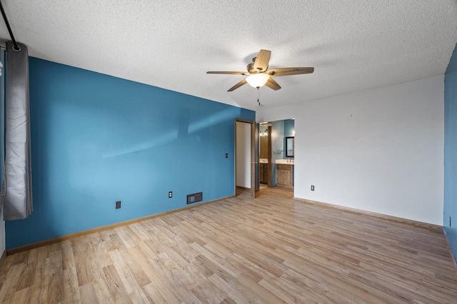 unfurnished room with baseboards, visible vents, ceiling fan, wood finished floors, and a textured ceiling