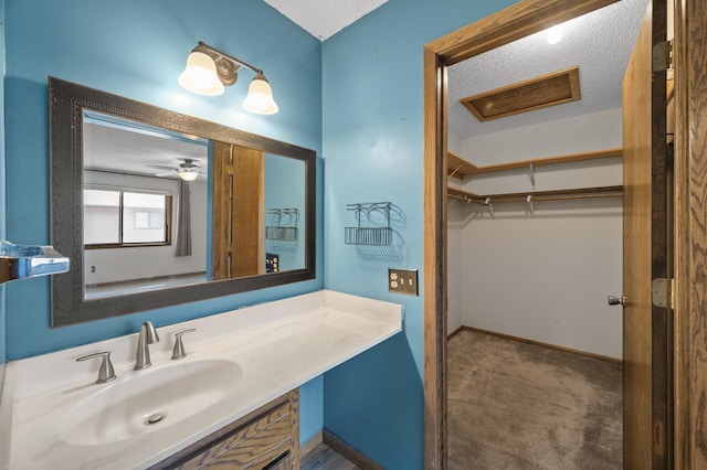 bathroom with a textured ceiling, vanity, and baseboards