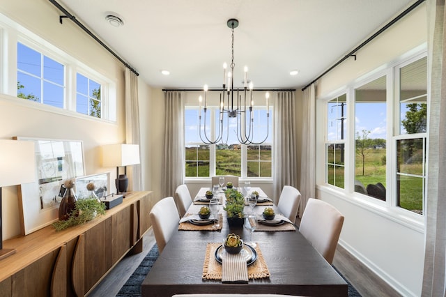 dining space with baseboards, dark wood finished floors, and a notable chandelier