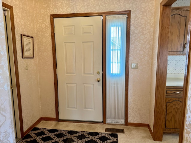 entryway featuring visible vents, baseboards, and wallpapered walls