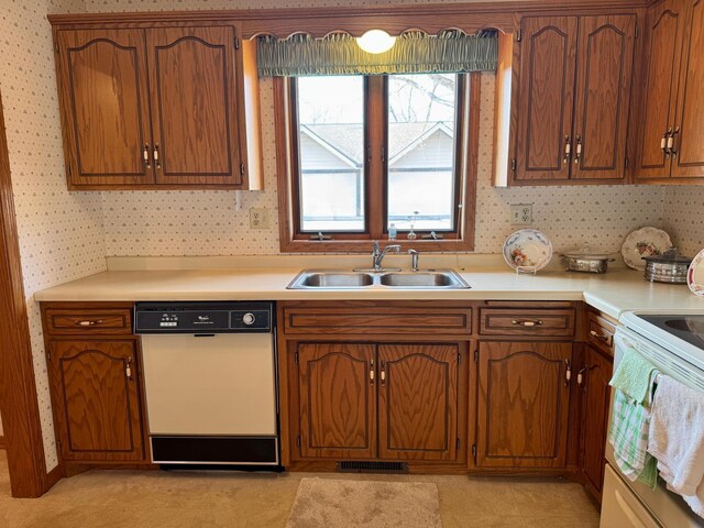 kitchen with light countertops, white appliances, a sink, and wallpapered walls