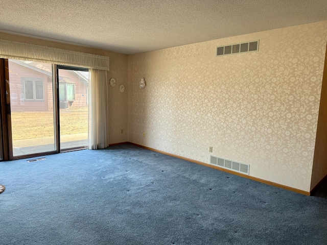 carpeted spare room featuring wallpapered walls, visible vents, and a textured ceiling