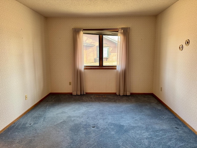 unfurnished room with carpet flooring, a textured ceiling, baseboards, and wallpapered walls