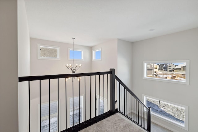 stairs with a chandelier and carpet flooring