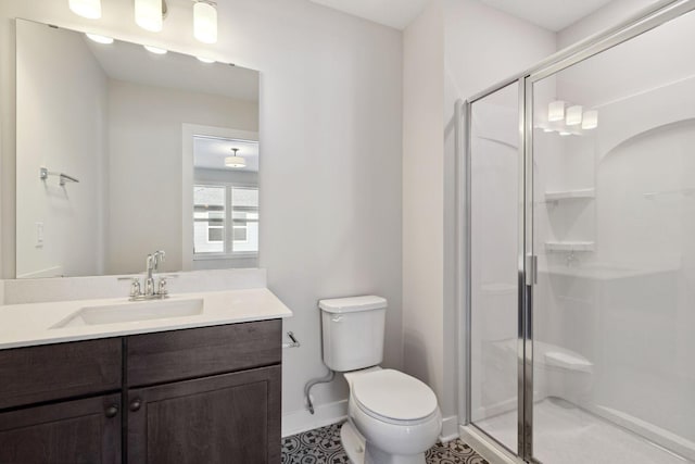 full bathroom featuring a stall shower, vanity, toilet, and baseboards